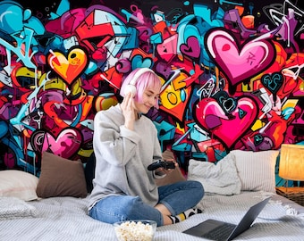 May include: A wall mural featuring a vibrant graffiti design with numerous pink and red hearts, abstract shapes, and bold lines in shades of blue, yellow, and purple. The artwork covers the entire wall surface, creating a colorful backdrop.