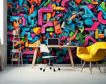 May include: A home office space featuring a wooden desk with a laptop, a white office chair, and a bright yellow armchair. The wall is covered in a vibrant, multi-colored graffiti mural with overlapping abstract shapes and letters in pink, blue, and orange.