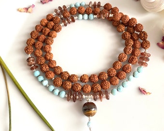 Mala from Larimar, Sunstone and Rudraksha, decorated with silver, final pearl tiger eye and Larimar