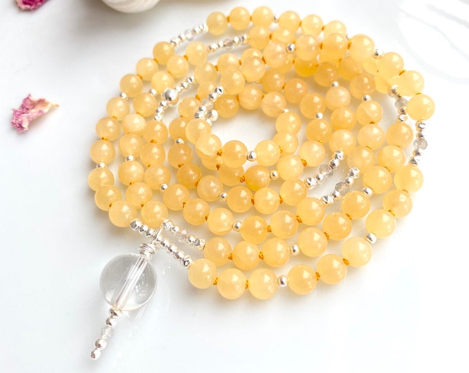 Mala made of bright orange calcite, decorated with silver and included quartz, final bead made of rock crystal