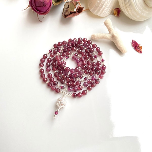 Mala made of light garnet, decorated with silver and violet garnet, final element ornamental bead made of silver, prayer beads