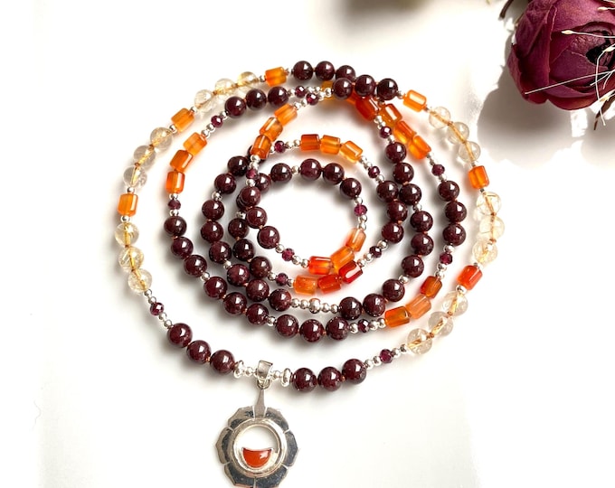 Mala made of garnet, carnelian and rutilated quartz with a silver pendant featuring the sacral chakra symbol Svadhisthana, yoga jewelry with chakra crystals