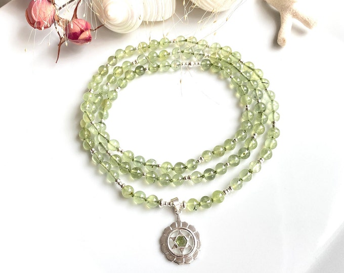 Mala made of glowing prehnite and silver pendant with the symbol for the heart - chakra - anahata - chakra, prayer beads