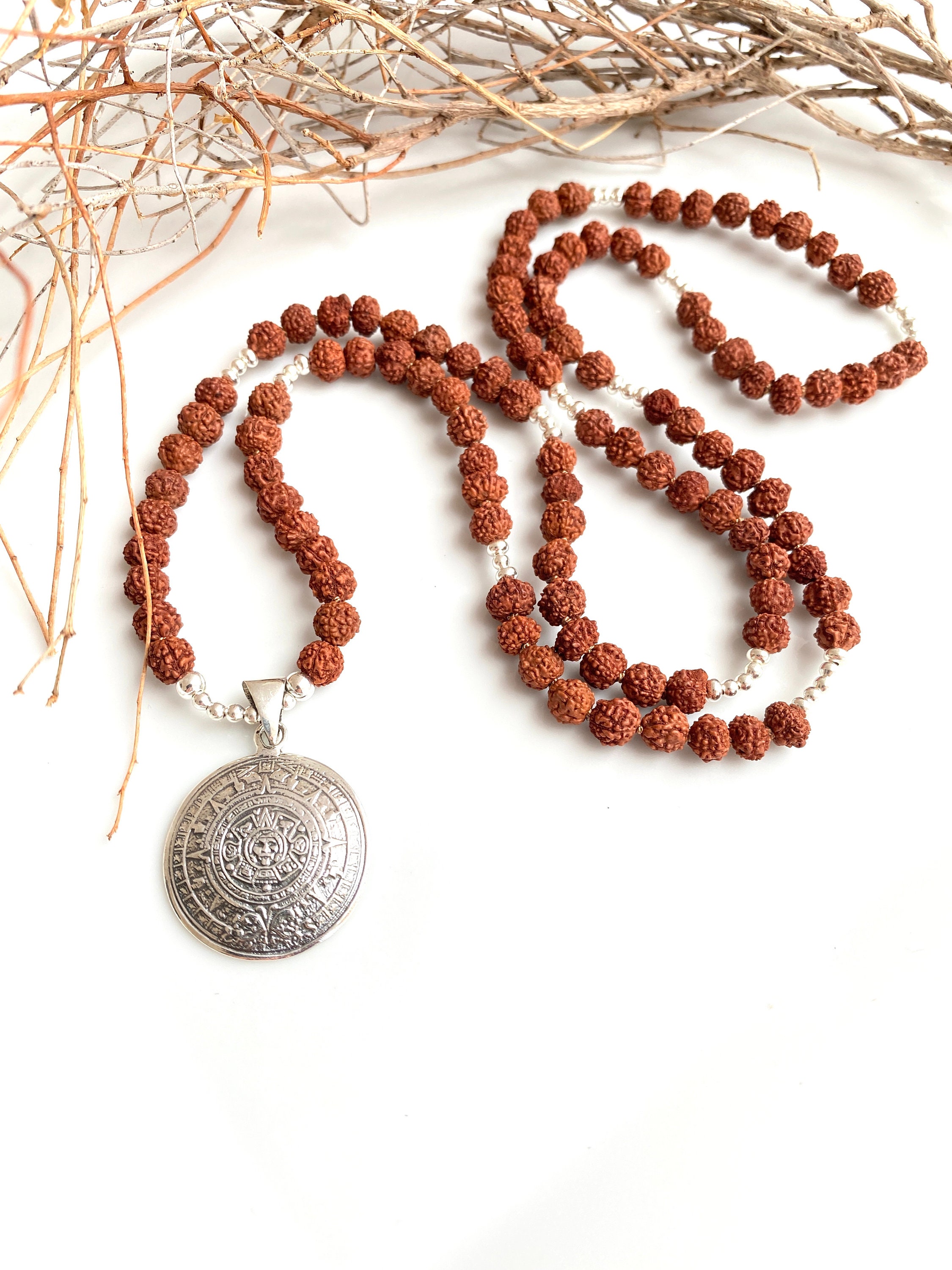 Mala aus kleinen Perlen aus Rudraksha mit silbernem Anhänger Sonnenrad ...
