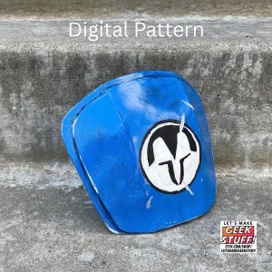 May include: A blue shoulder armor piece featuring a white circular emblem with a black stylized helmet design. The text Digital Pattern is visible at the top, and a logo with the text LET'S MAKE GEEK STUFF is in the bottom corner.