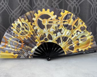 Steampunk Gears of Golden Yellows on a Large Clack Fan Designed by Tara and Manufactured in Small Limited Edition Batches