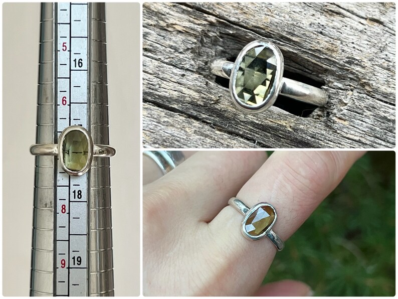 May include: A silver ring with a green oval gemstone. The ring is shown on a ring sizer and on a finger.