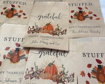 May include: A collection of brown paper bags featuring Thanksgiving-themed graphics. Some bags display the word STUFFED with a turkey illustration, while others feature the word grateful, a pumpkin, and personalized text.