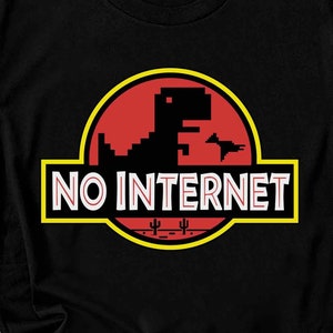 Op de afbeelding: Zwart T-shirt met een afbeelding van het klassieke 'Geen internet'-dinosaurusspel. De afbeelding is in een geel, rood en zwart kleurenschema en zegt 'GEEN INTERNET' in witte tekst.