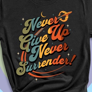May include: Black t-shirt with a retro-style graphic that says "Never Give Up Never Surrender!" with a rocket ship and stars.
