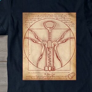 May include: Navy blue t-shirt featuring a corkscrew design within a circle, reminiscent of Da Vinci's Vitruvian Man. The design is in shades of brown and red. A pair of blue sneakers and a pair of jeans are also visible.
