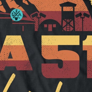 May include: A vintage-style graphic with the text "Area 51" in a retro font. The graphic features a sunset background with a silhouette of a building with a watchtower and a fence. The text is in a red, orange, and yellow color scheme.