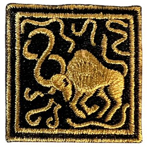 May include: A gold embroidered patch with a black background featuring a stylized bull design.