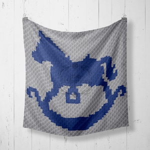 May include: A gray and blue crocheted blanket with a rocking horse design. The rocking horse is blue and the blanket is gray with a subtle pattern.