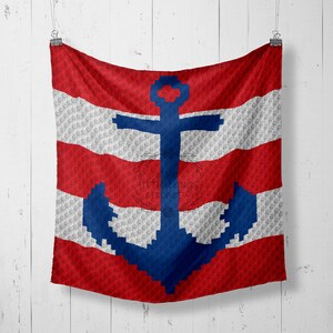 May include: Red, white, and blue striped fabric with a blue anchor in the center. The fabric is hanging from a white wall.