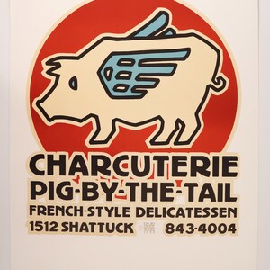 Könnte beinhalten: Ein roter Kreis mit einem weißen Schwein mit blauen Flügeln, das fliegt. Der Text darunter lautet "CHARCUTERIE PIG-BY-THE-TAIL FRENCH-STYLE DELICATESSEN 1512 SHATTUCK 843-4004".