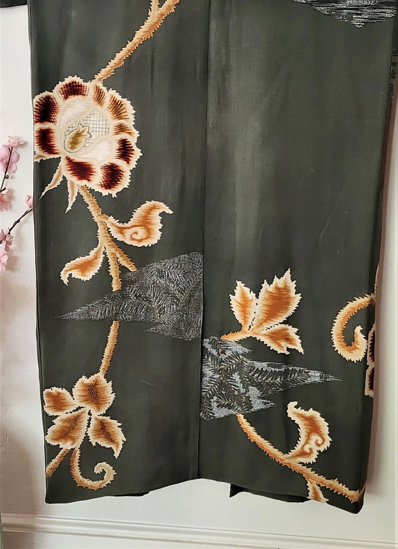 May include: A dark green kimono with a floral pattern in shades of brown and cream. The kimono has a traditional Japanese design with intricate details.
