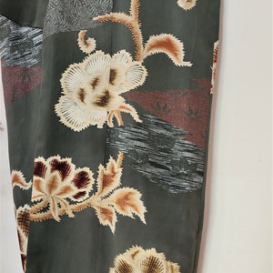 May include: A dark green kimono with a floral pattern in shades of brown, white, and red. The kimono has a traditional Japanese design with intricate details.