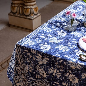Puede incluir: Un mantel estampado en azul y blanco con un plato blanco y flores rosas en un jarr&oacute;n de vidrio.
