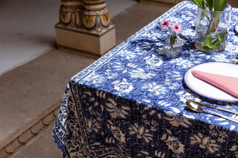 Puede incluir: Un mantel estampado en azul y blanco con un plato blanco y flores rosas en un jarr&oacute;n de vidrio.