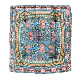 May include: A blue and orange floral patterned cushion with a quilted design and a decorative border.