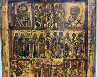May include: An antique wooden icon depicting a religious scene with multiple figures. The icon is painted in black and gold with a worn, aged appearance. The figures are depicted in a traditional style with detailed clothing and facial features.