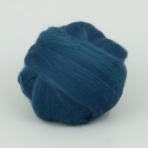 May include: A ball of teal-coloured wool roving, tightly wound. The wool has a soft, fluffy texture and a slight sheen. The colour is a deep, rich teal with subtle variations in tone. Suitable for fibre art projects.