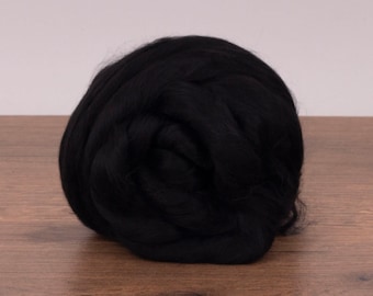 Könnte beinhalten: Ein großer Ball schwarzer Wollfasern. Die Wolle ist weich und flauschig und perfekt zum Spinnen oder Filzen.