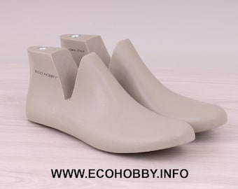 May include: Two light gray shoe forms, designed for shaping and maintaining the structure of footwear. The forms are made of a solid material and feature a smooth, curved design. The text "ECO HOBBY" is printed on the side, and the website address is at the bottom.