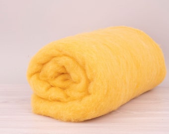 Pode incluir: Um rolo de mecha de lã amarelo brilhante. A lã tem uma textura macia e fofa e é bem enrolada. A cor é um amarelo vibrante e ensolarado, sugerindo calor e maciez. Este é um material de artesanato para feltragem ou outras artes de fibra.
