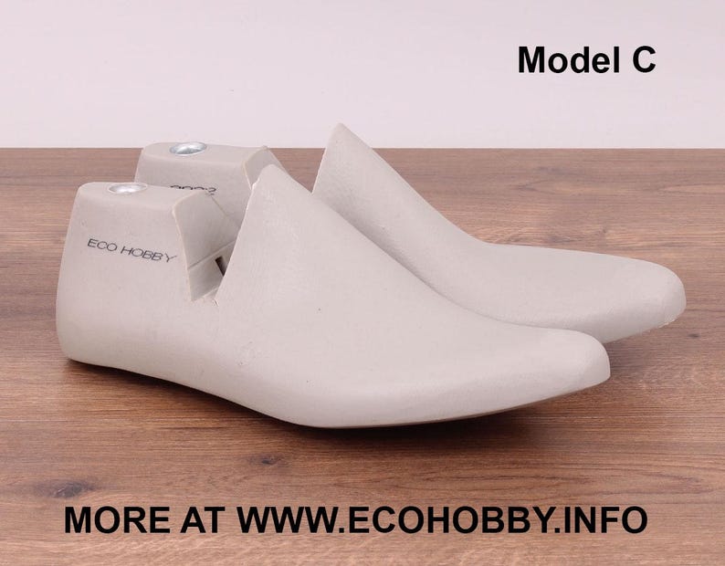 May include: A pair of light gray shoe lasts, Model C, made of a smooth material. The text "ECO HOBBY" is printed on the side of one last. The website address "MORE AT WWW.ECOHOBBY.INFO" is printed at the bottom.