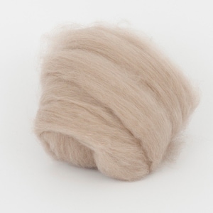 May include: A mass of light tan wool fibers, tightly packed and slightly curled. The fibers have a soft, fluffy appearance, suggesting a natural textile material. The wool is likely used for crafting or textile projects.