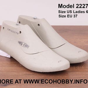 Puede incluir: Un par de hormas de zapatos blancas, etiquetadas con "OP22278" y "N-AB!" con el número de modelo "22278" y las tallas "US Ladies 6.5" y "EU 37".