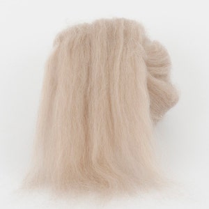 May include: A light beige, fluffy material, possibly yarn or fiber, is displayed against a white background. The material appears soft and delicate, with a slightly ruffled texture. The overall impression is of a natural, airy textile.
