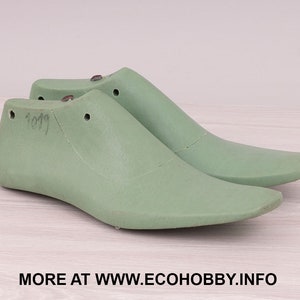 Puede incluir: Dos hormas de zapatos verde claro, una al lado de la otra, con un diseño suave y curvado. Cada horma tiene un talón redondeado y una punta puntiaguda. El texto "1019" está escrito en el lateral de una de las hormas. Imagen de hormas de zapatos.