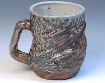 3D printed fully functional ceramic coffee or tea mug high fired reduction stoneware with a soda glaze. Has a white shino liner glaze inside