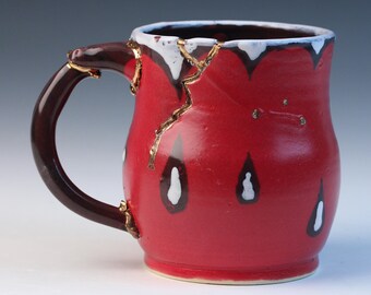 Kintsugi, Wabi Sabi inspired functional handmade black and red ceramic coffee or tea mug with decorative real 22k gold repair