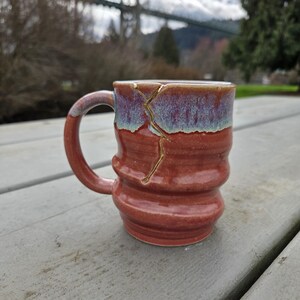 May include: A set of three ceramic mugs with a speckled, matte finish. The mugs are in shades of cream, light gray, and dark gray. Each mug has a simple, minimalist design, perfect for coffee or tea.
