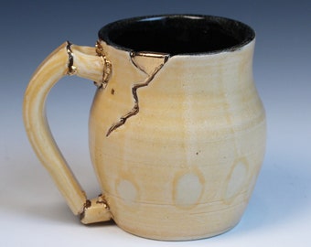 Kintsugi, Wabi Sabi inspired functional handmade cream and black ceramic coffee or tea mug with texture and decorative gold repair