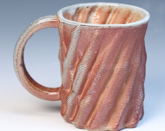 3D printed fully functional ceramic coffee or tea mug high fired reduction stoneware with a soda glaze. Has a white shino liner glaze inside