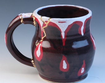 Kintsugi, Wabi Sabi inspired functional handmade black and red ceramic coffee or tea mug with decorative real 22k gold repair