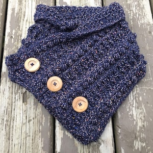 May include: A navy blue crocheted cowl with a speckled pattern and three wooden buttons.