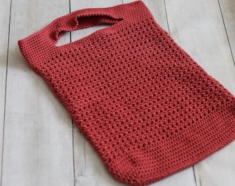 May include: A red crocheted tote bag with a single handle. The bag is made with a simple stitch pattern and has a slightly textured surface.