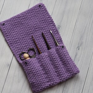 May include: Purple crocheted needle case with three crochet hooks and a pair of scissors inside.