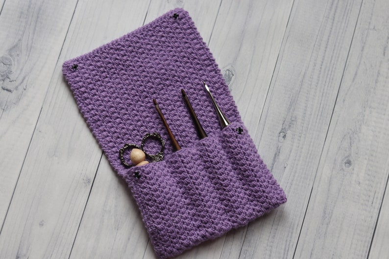 May include: Purple crocheted needle case with three crochet hooks and a pair of scissors inside.