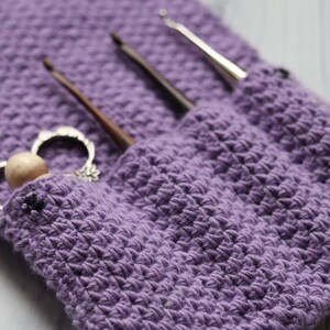 May include: Purple crocheted pouch with three crochet hooks and a vintage-style crochet hook holder.