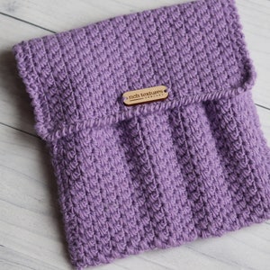 May include: A purple knitted pouch with a flap closure and a wooden tag that reads "rich textures".