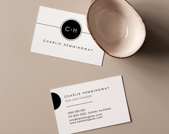 May include: A white business card with black text and a black circle containing the initials "C-H" for Charlie Hemingway, CEO and Founder. The card includes contact information: phone number, PO Box, email address, and website.