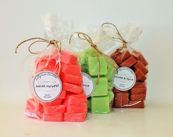 Puede incluir: Tres bolsas de cera para fundir, cada una con un aroma diferente. Las bolsas están atadas con cuerda y tienen etiquetas con los aromas: "Amish Harvest", "Spruce" y "Strudel & Spice".