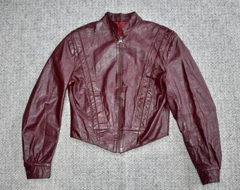 Peut inclure: Une veste en cuir bordeaux avec une fermeture éclair et un col montant.